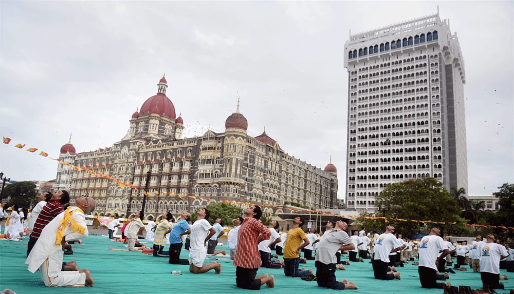 People perform yoga during a mass yoga event