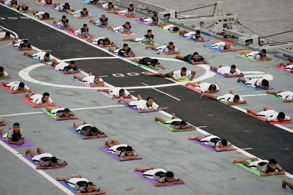 People from the Naval staff perform yoga during a mass yoga