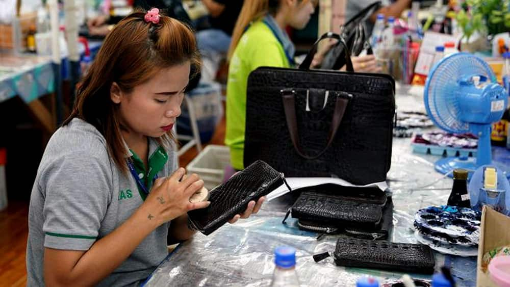 A worker polishes a wallet made from crocodile skin