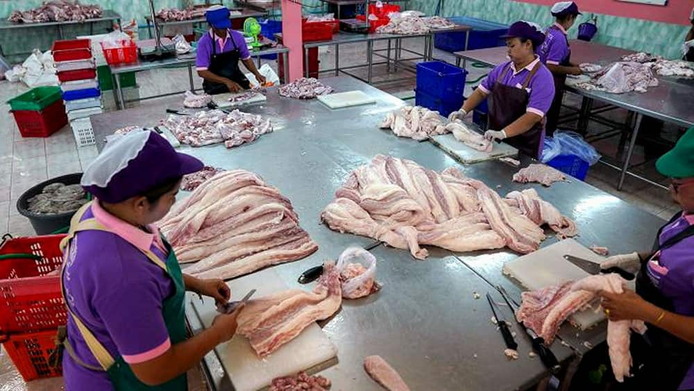 Workers process crocodile meat at a slaughterhouse