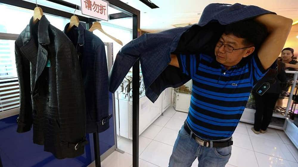 A Chinese tourist tries on a jacket made from crocodile skin