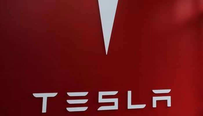Tesla&#039;s Elon Musk hands over first Model 3 electric cars to early buyers