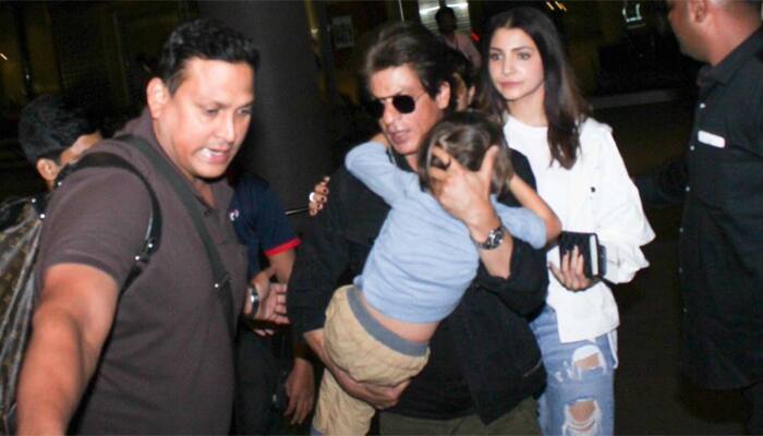 Shah Rukh Khan plays doting dad, hides son AbRam from paparazzi! - See pics