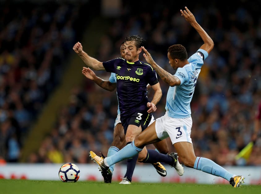 Everton's Leighton Baines tries to dribble past two Manchester City players