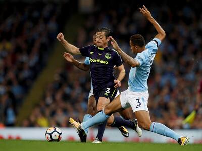 Everton's Leighton Baines tries to dribble past two Manchester City players