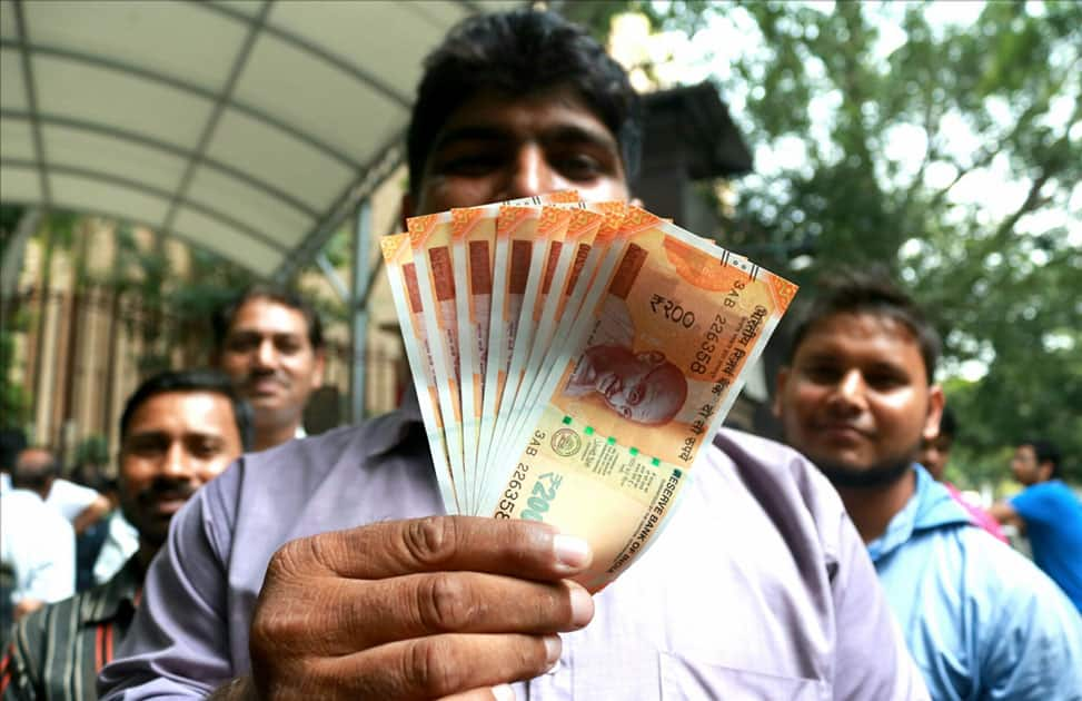 A man shows the new Rs 200 currency note