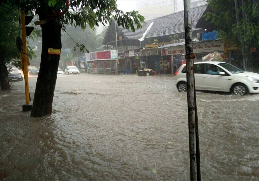 Vehicles struggle through a water-logged street after rains