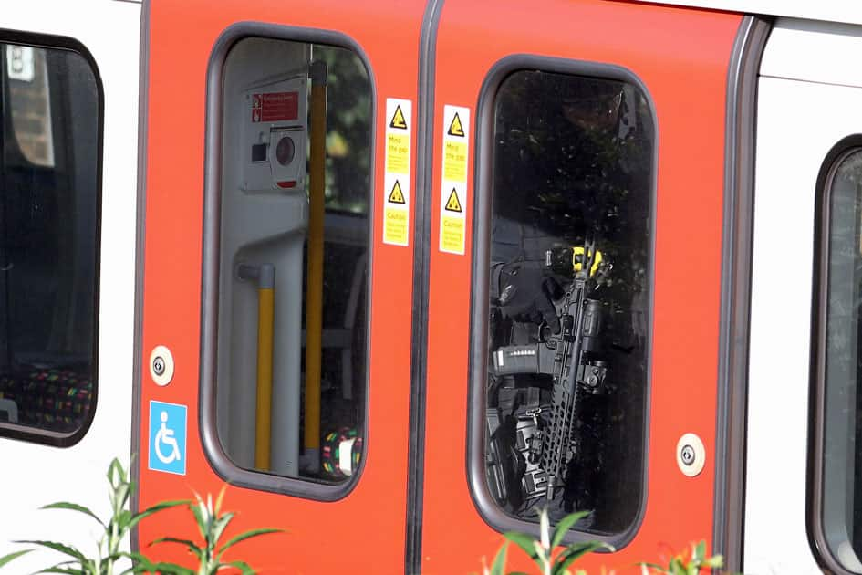 Armed police officers walk through a carriage of a London underground tube train at Parsons Green station in London