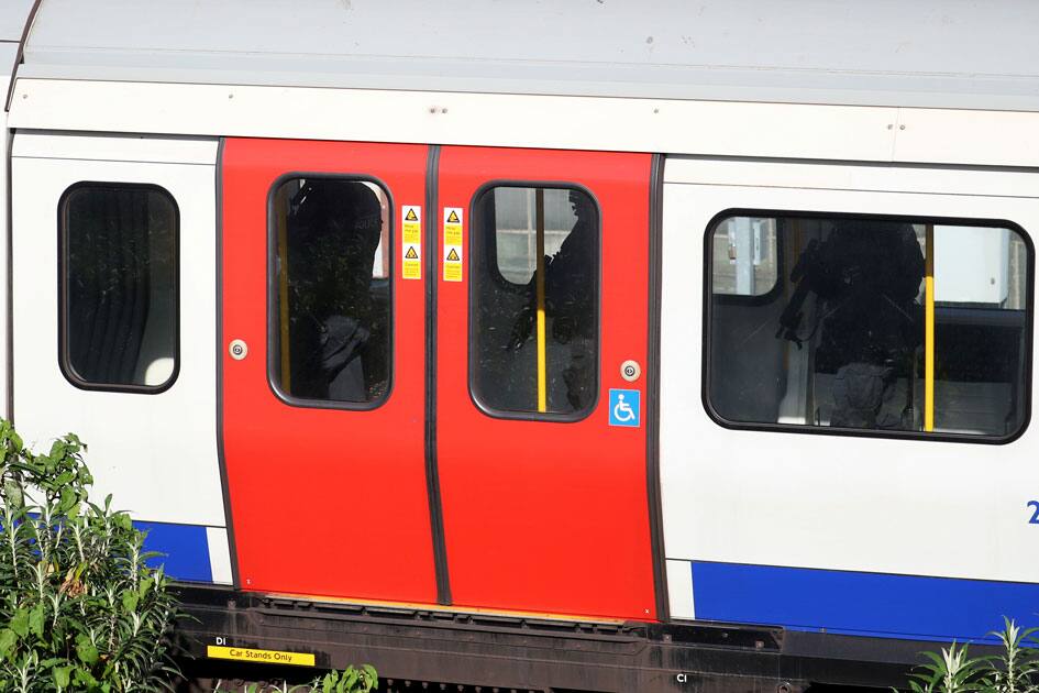 Armed police officers walk through a carriage of a London underground tube train at Parsons Green station in London, Britai