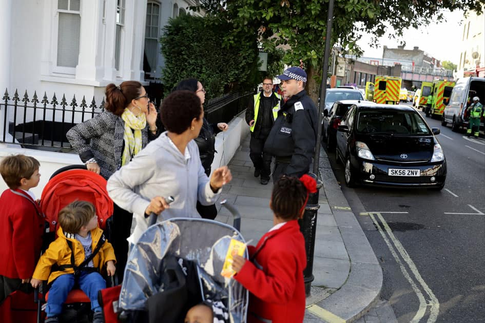 People speak with a police officer outside Parsons Green tube station in London