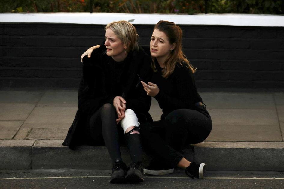 An injured woman reacts outside Parsons Green tube station in London