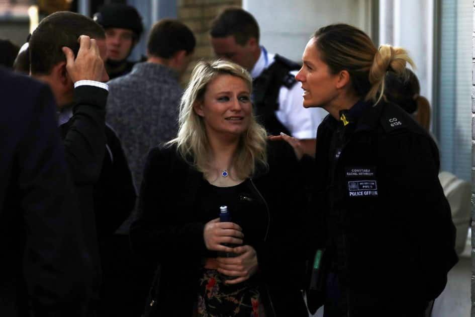 A woman reacts outside Parsons Green tube station in London