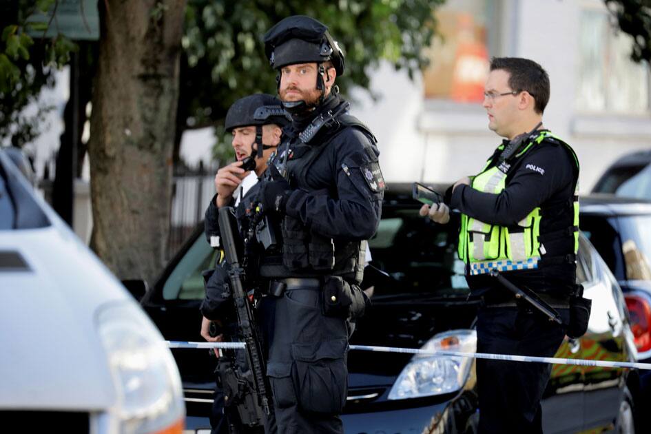 Armed policemen stand by cordon outside Parsons Green tube station in London, Britain