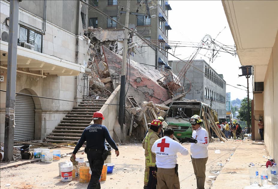 Rescuers work at a collapsed building after an earthquake in Cuernavaca City, Morelos State, Mexico