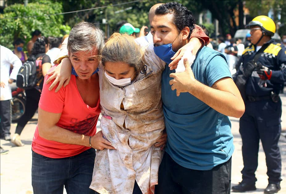 People help a woman after an earthquake in Mexico City, capital of Mexico