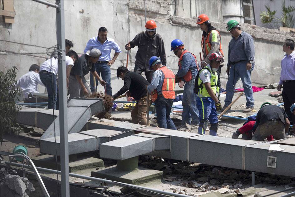 People work on the roof of a collapsed building after an earthquake in Mexico City, capital of Mexico