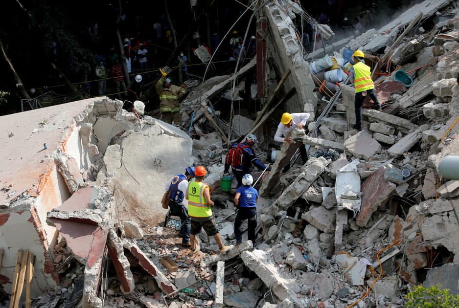 Rescue personnel remove rubble at a collapsed building while searching for people after an earthquake hit Mexico City, Mexico