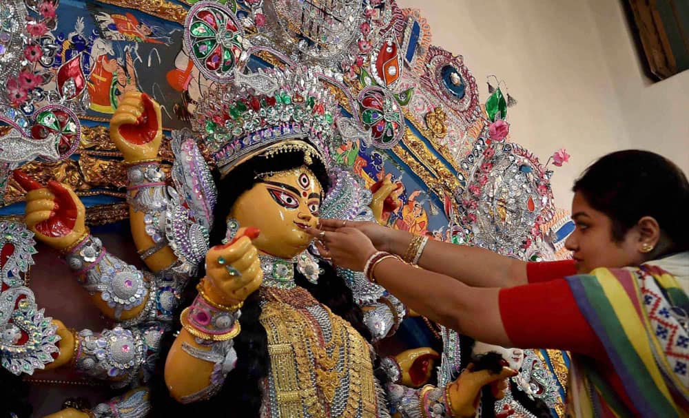 An idol of Goddess Durga being being decorated with gold ornaments during Durga Puja festival in Kolkata.