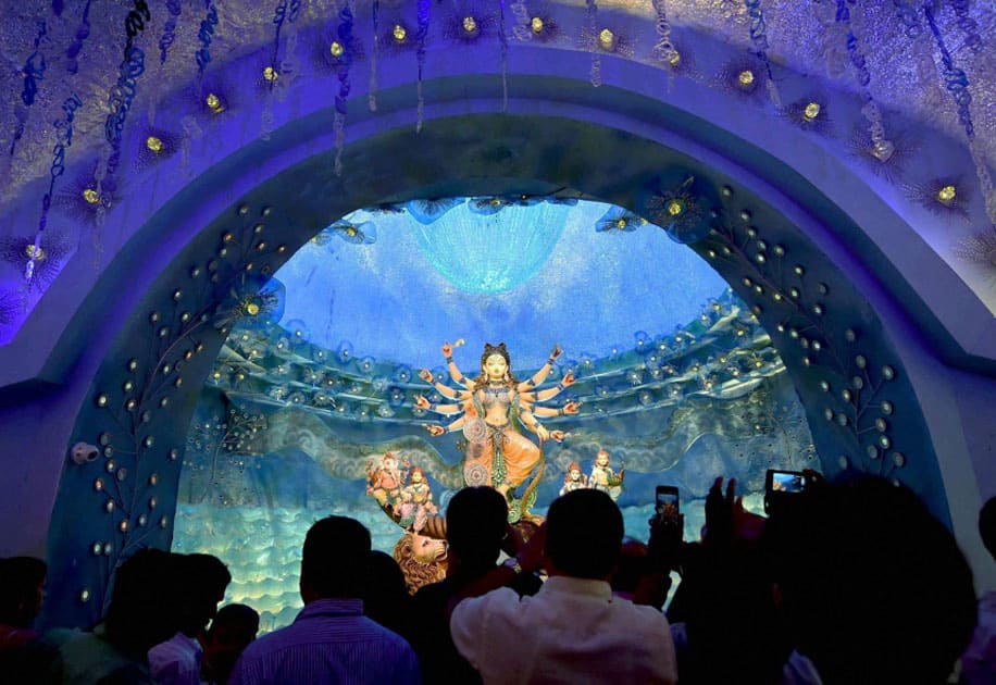 Visitors taking pictures of the Devi Durga idol installed at a community puja pandal in Kolkata.