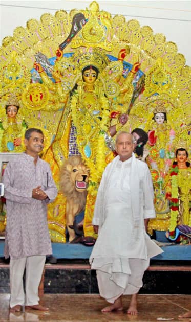 Former President of India Pranab Mukherjee with his son and MP Abhijit Mukherjee standing in front of idol of Goddess Durga at his ancestral home in Mirati village in Birbhum district of West Bengal.