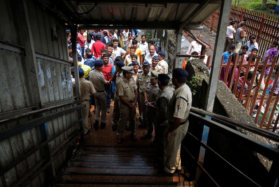 Policemen inspect the site of a stampede at a railway station's pedestrian overbridge in Mumbai.