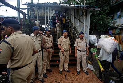 Policemen inspect the site of a stampede at a railway station's pedestrian overbridge in Mumbai.