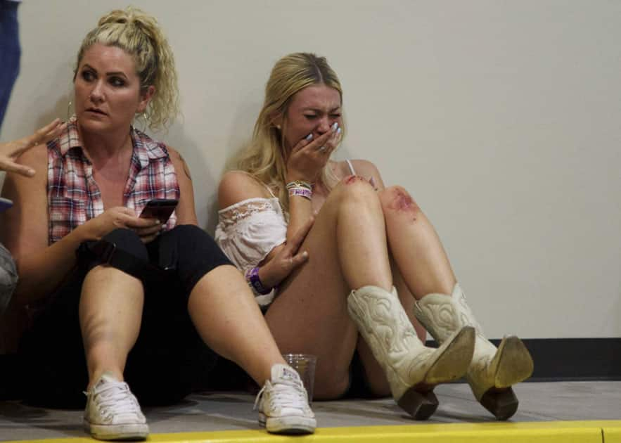 A woman cries while hiding inside the Sands Corporation plane hangar after a mass shooting in which dozens were killed at the Route 91 Harvest Festival in Las Vegas.