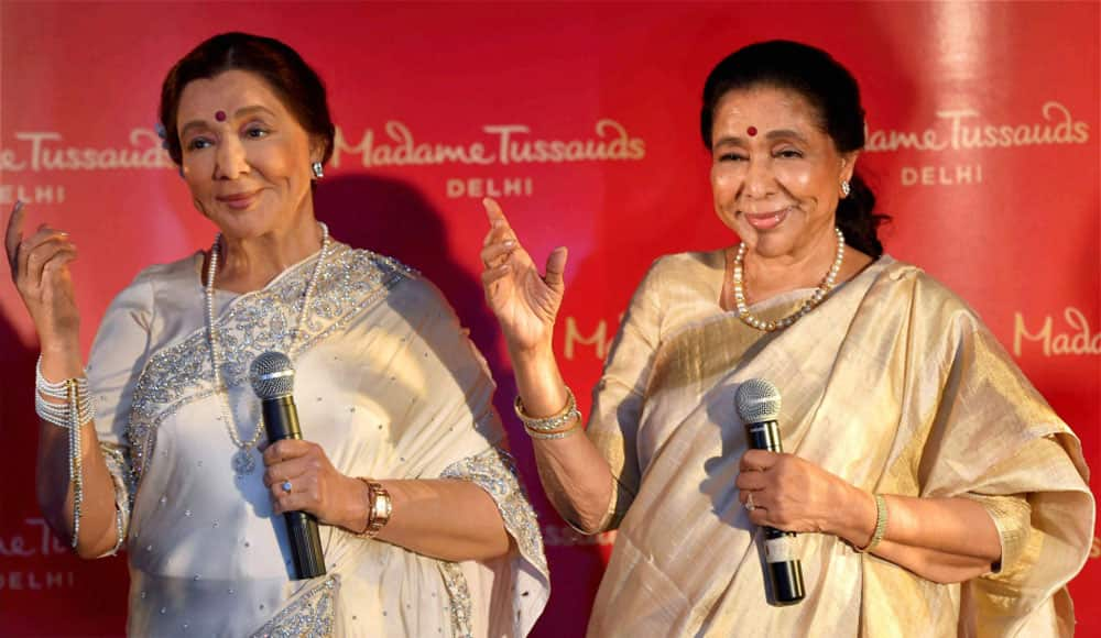 Legendary singer Asha Bhosle poses with her wax-statue during its unveiling, in New Delhi.