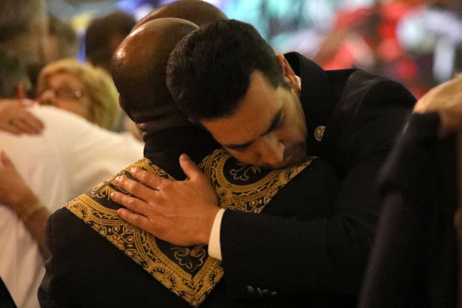 People mourn during an interfaith memorial service for victims of the Route 91 music festival mass shooting outside the Mandalay Bay Resort and Casino in Las Vegas.