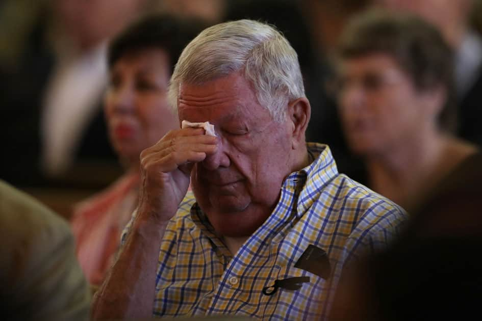 People mourn during an interfaith memorial service for victims of the Route 91 music festival mass shooting outside the Mandalay Bay Resort and Casino in Las Vegas.