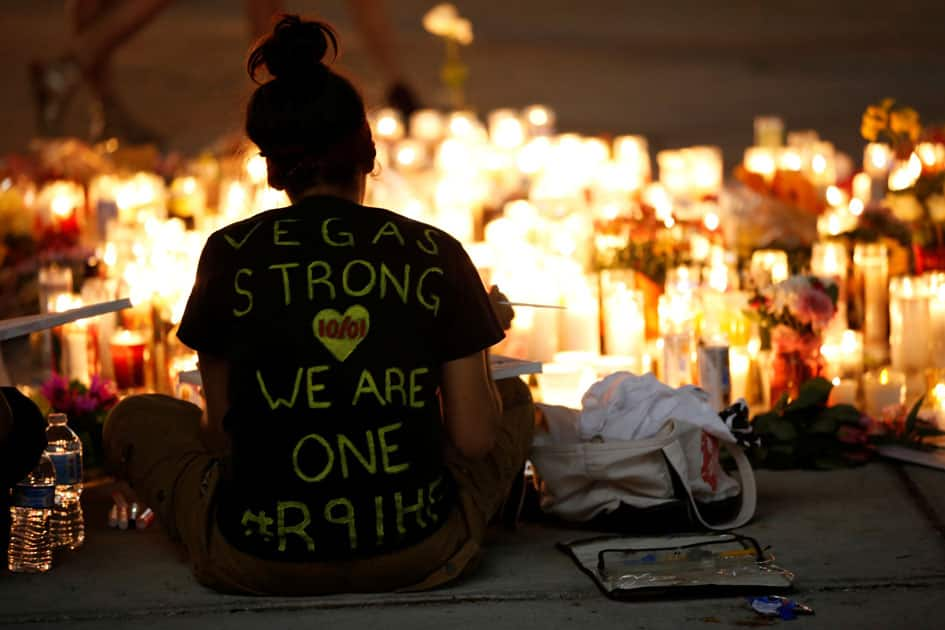 A woman makes a sign at a vigil on the Las Vegas strip following a mass shooting at the Route 91 Harvest Country Music Festival in Las Vegas.