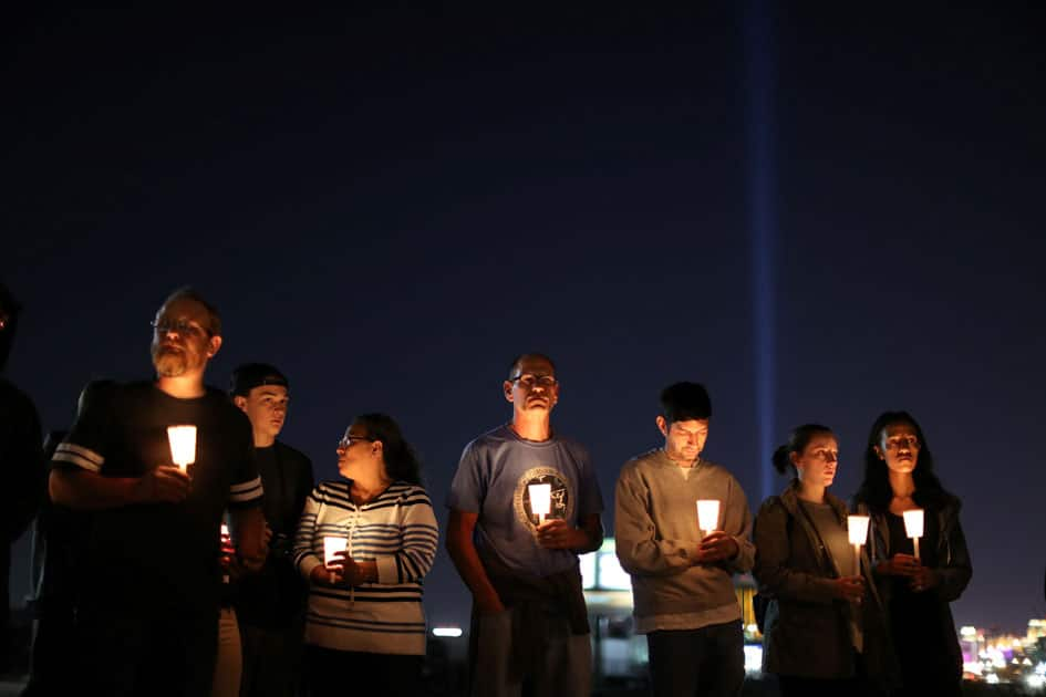 People pray during a candlelight vigil for victims of the Route 91 music festival mass shooting next to the Mandalay Bay Resort and Casino in Las Vegas