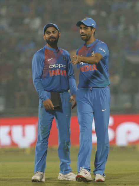 Indian skipper Virat Kohli interacts with Ashish Nehra during the first T20 match between India and New Zealand at Feroz Shah Kotla stadium in New Delhi.
