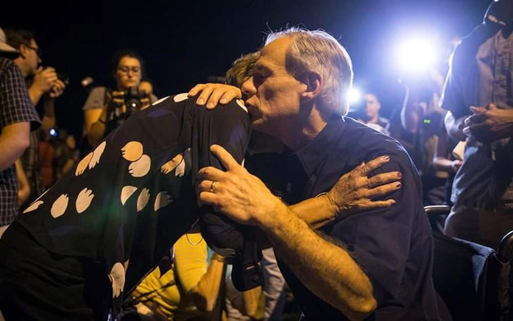 Texas Governor Greg Abbott embraces a woman at a vigil following a mass shooting at the First Baptist Church in Sutherland Springs.