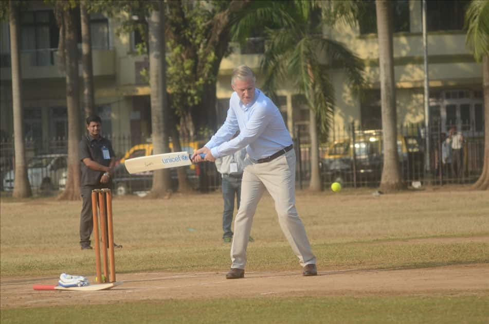 Belgium's King Philippe, Queen Mathilde and former Indian cricketer Virender Sehwag play cricket with under privileged children during an event hosted by UNICEF in Mumbai.