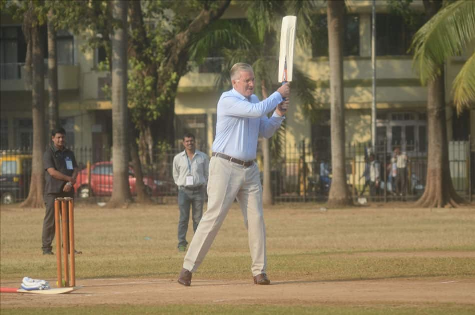 Belgium's King Philippe, Queen Mathilde and former Indian cricketer Virender Sehwag play cricket with under privileged children during an event hosted by UNICEF in Mumbai.