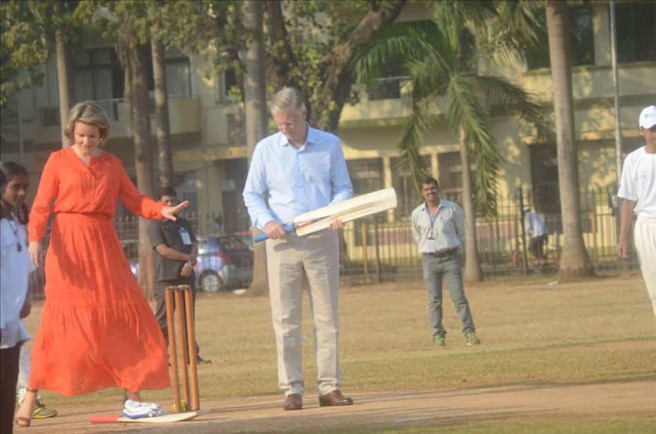 Belgium's King Philippe, Queen Mathilde and former Indian cricketer Virender Sehwag play cricket with under privileged children during an event hosted by UNICEF in Mumbai.