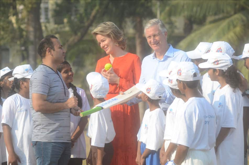 Belgium's King Philippe and Queen Mathilde and former Indian cricketer Virender Sehwag play cricket with under privileged children during an event hosted by UNICEF in Mumbai.