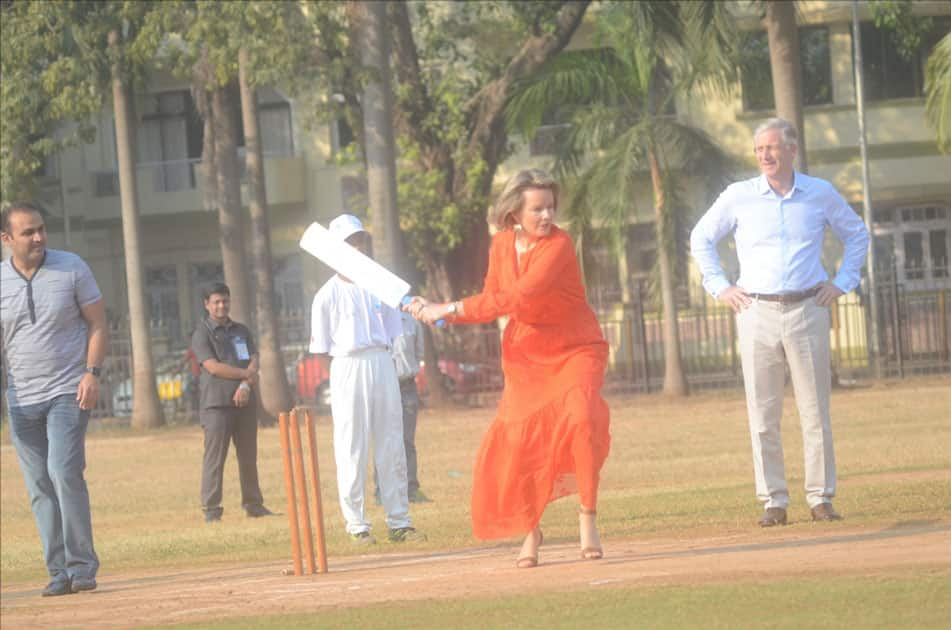 Belgium's King Philippe and Queen Mathilde and former Indian cricketer Virender Sehwag play cricket with under privileged children during an event hosted by UNICEF in Mumbai.