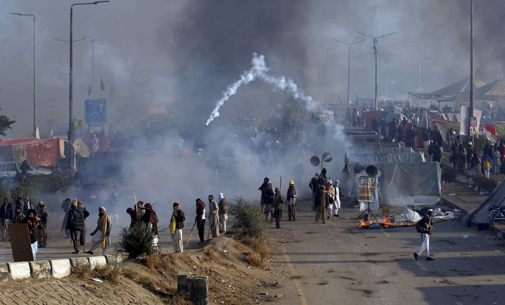 Protesters hurls back a tear gas shell fired by police during a clash in Islamabad, Pakistan.