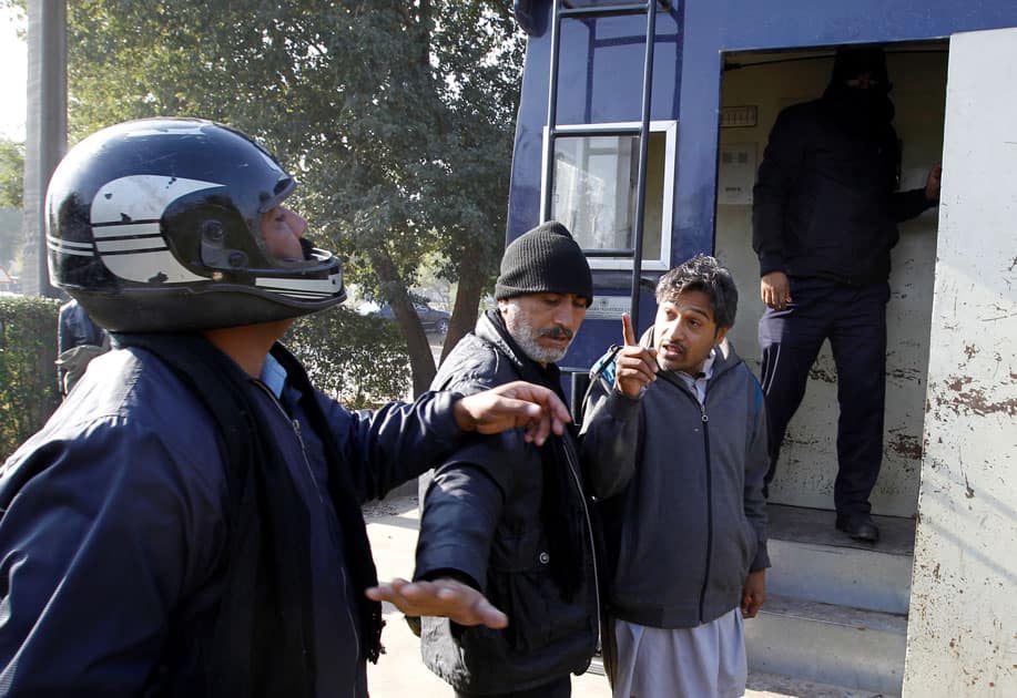 A demostrator detained by police gestures after being hit by a policeman as he is led to a police van near the Faizabad junction in Islamabad.