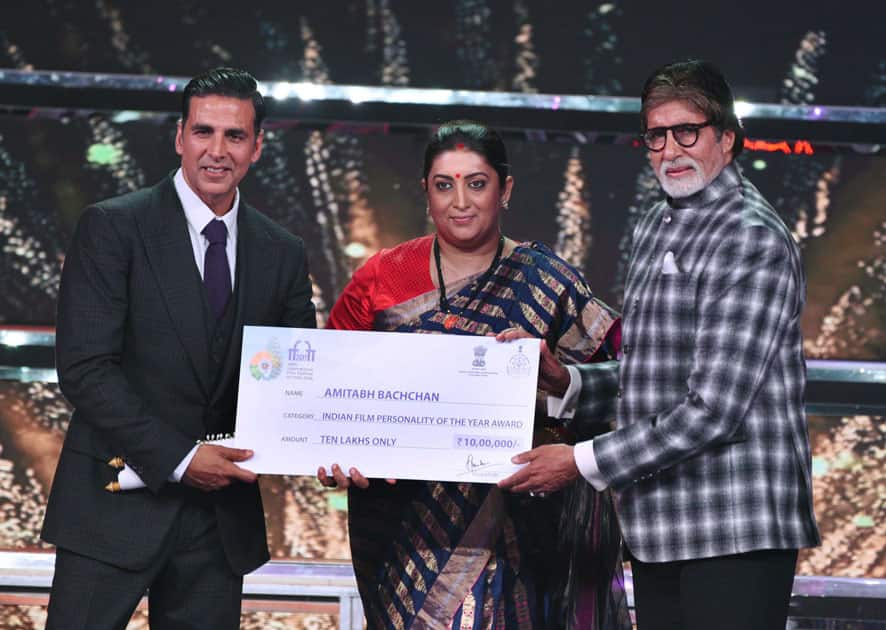 Union Minister for Textiles and Information and Broadcasting Smriti Irani presents the Indian Film Personality of the Year Award to actor Amitabh Bachchan