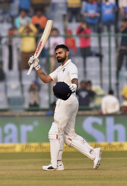 Indian skipper Virat Kohli raises his bat after scoring a century against Sri Lanka during the first day of third cricket test match at Feroz Shah Kotla, in New Delhi.