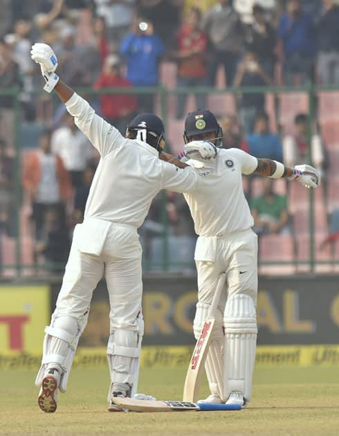 Indian cricketer Murali Vijay celebrates with skipper Virat Kohli after completing his century against Sri Lanka during the first day of the third cricket test match at Feroz Shah Kotla, in New Delhi.