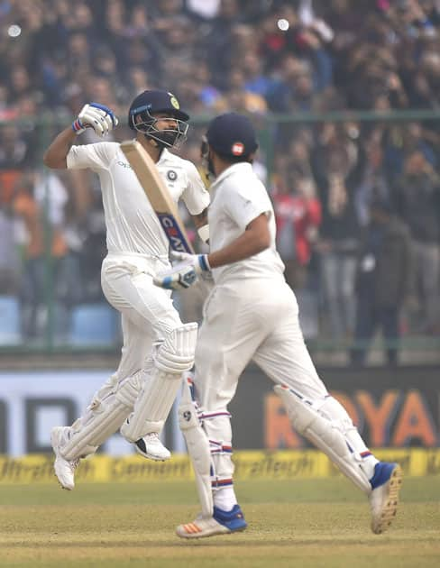 India's Virat Kohli exults after his double century against Sri Lanka as teammate Rohit Sharma looks on, during the second day of the third cricket test match at Feroz Shah Kotla, in New Delhi.