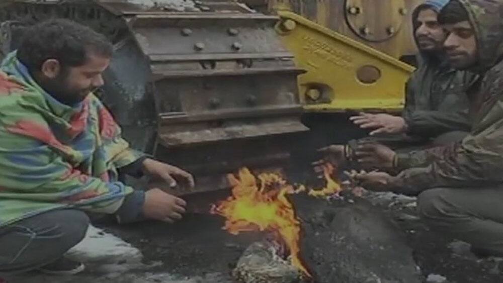 Pir Panjal range continues to receive snowfall, Mughal road closed for traffic. People light fire to battle cold wave, Rajouri, Jammu and Kashmir. Pir Panjal range continues to receive snowfall, Mughal road closed for traffic. People light fire to battle cold wave, Rajouri, Jammu and Kashmir.