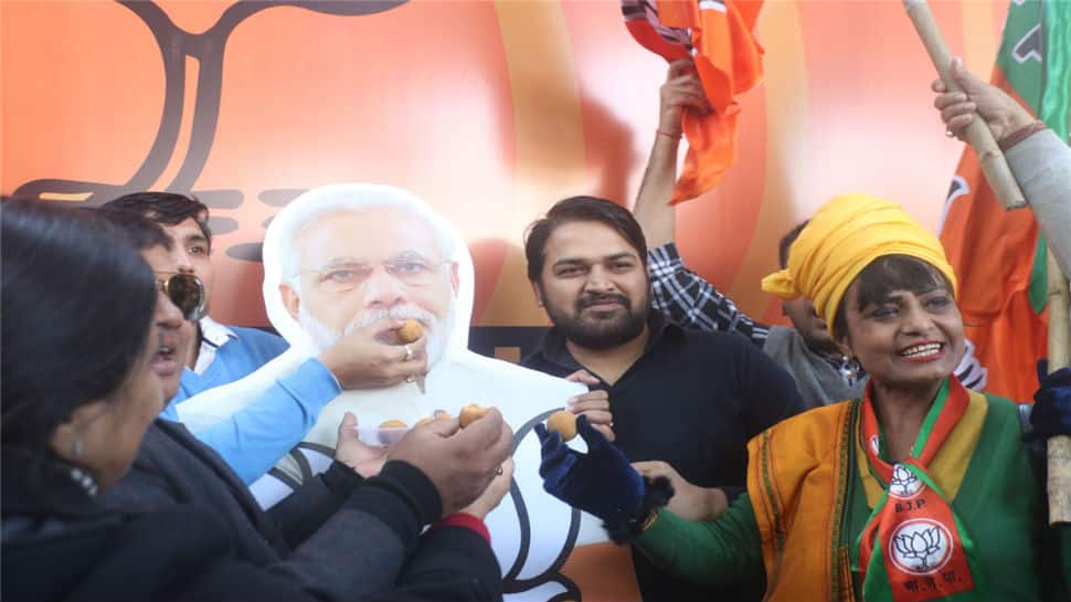 Party workers with posters of PM Modi were seen distributing sweets