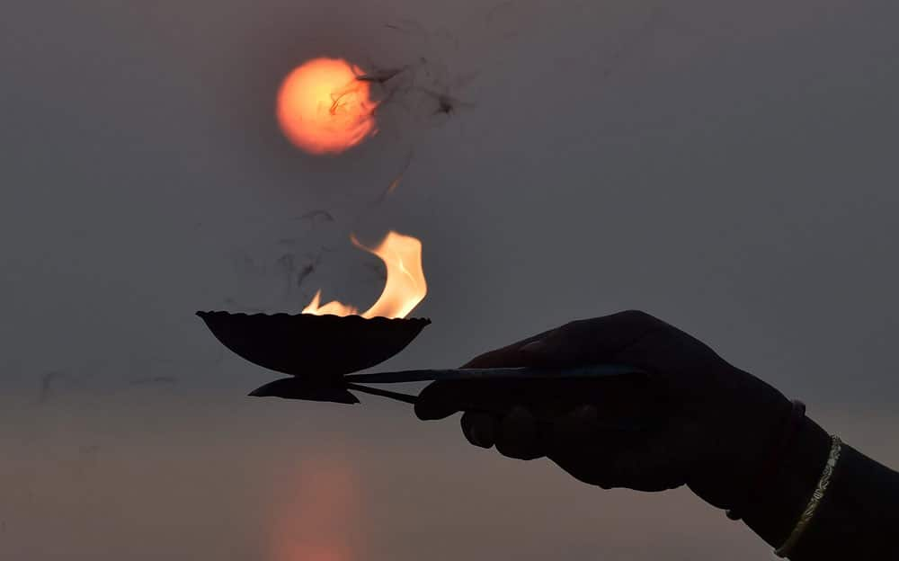 A devotee offering evening prayers to the Sun on the occasion of 