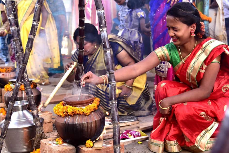 Women prepare sweet pongal on the occasion of Makar Sankranti at Sudhamnagar in Bengaluru.