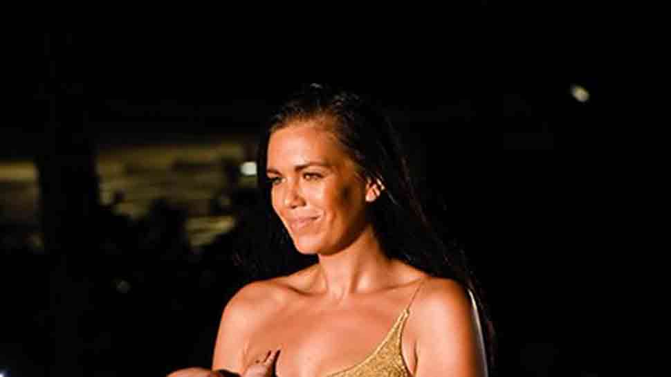 Model Mara Martin breastfeeds baby while walking swimsuit runway